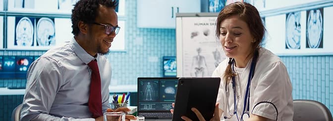 Medical professional holding a tablet computer during a medical team consultation.