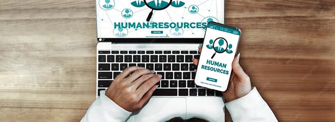Top-down shot of a laptop and mobile screen showing human resources graphics.