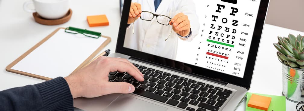 An online vision test showing a Snellen chart and optometrist on a laptop screen.