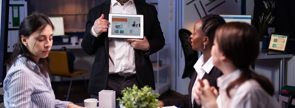 Professional presenting a financial executive scoreboard on a tablet during a conference.